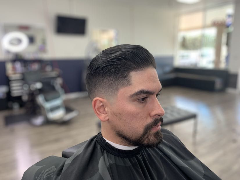 Swept back haircut with a fade and shaped beard by Pedro